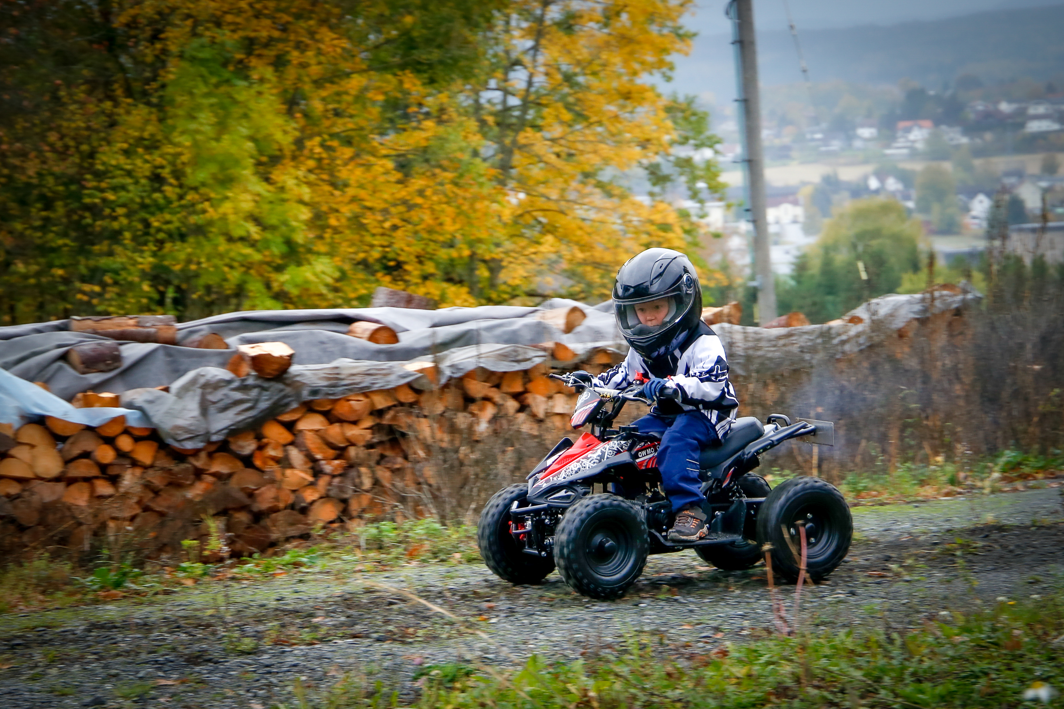 Barn som kjører ATV på gårdsplassen